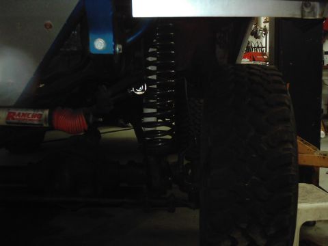 1978 Ford Bronco - The image shows a close-up view of a vehicle's suspension components, including a coil spring and a shock absorber.