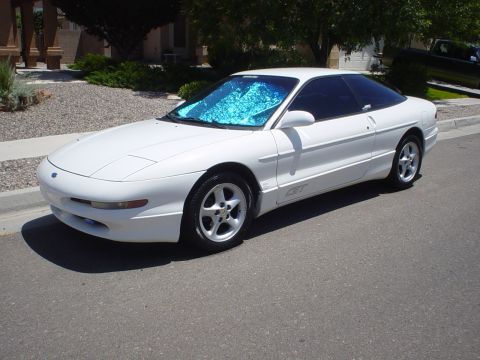 1993 Ford Probe - A white 1993 Ford Probe GT is parked on a residential street, its windshield covered by a blue sunshade.