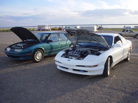 1993 Ford Probe - A white 1993 Ford Probe is parked next to a teal sedan, both with hoods open.