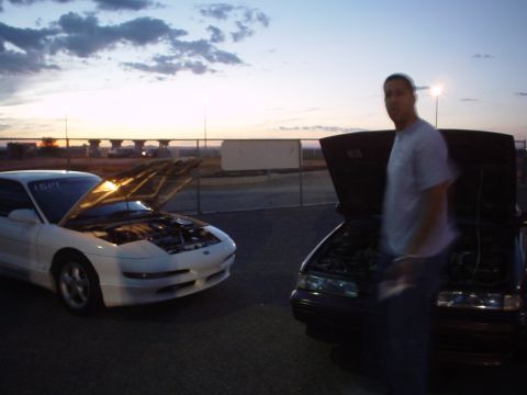 1993 Ford Probe - Two cars, a 1993 Ford Probe and another sedan, sit with hoods open at dusk.