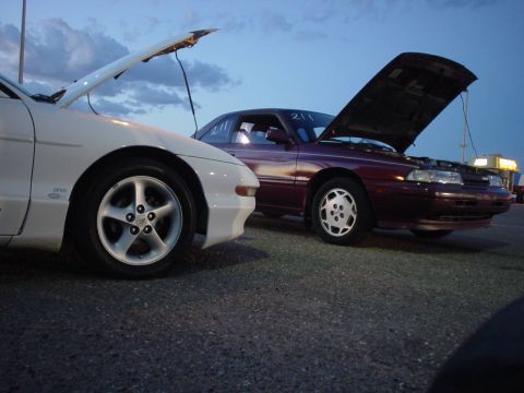 1993 Ford Probe - Two cars parked with their hoods open, possibly at a track event.
