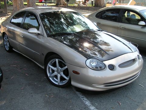 1993 Ford Taurus - This Ford Taurus has a custom black hood and aftermarket wheels.