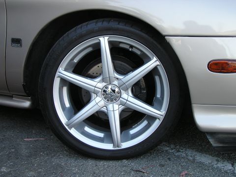 1993 Ford Taurus - Aftermarket wheel and fender detail on a car, a '24V DOHC' badge.