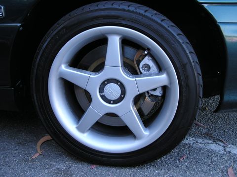 1993 Ford Taurus - A close-up view of a vehicle's wheel and tire, highlighting the brake system and aftermarket wheel.