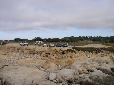 1993 Ford Taurus - A scenic view of a rocky coastline with several vehicles parked along the edge.