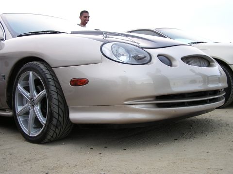 1993 Ford Taurus - Front view of a tan car, possibly a 1998 Ford Taurus, with custom wheels and a contrasting black hood accent.