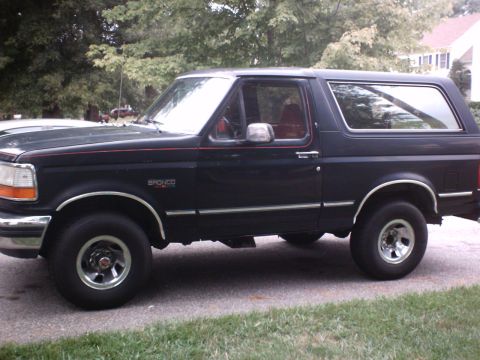 1989 Ford Bronco - This black Ford Bronco SUV is shown from the side, with visible 'Bronco' badging and chrome accents.