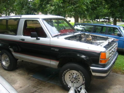 1989 Ford Bronco II - This 1989 Ford Bronco II is shown with its hood open, parked next to another vehicle.