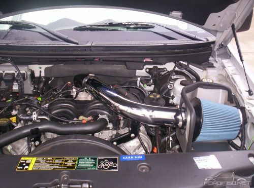 Engine bay with chrome intake tube and blue cone air filter in a Ford pickup