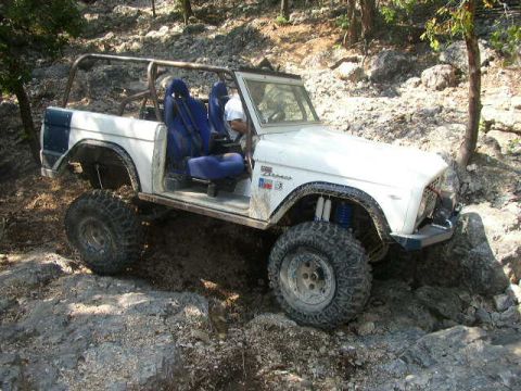 1995 Ford Bronco - This modified 1978 Ford Bronco navigates a rocky, off-road trail with its large tires and exposed interior.