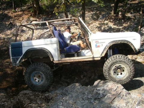 1995 Ford Bronco - Modified 1995 Ford Bronco tackling rough, rocky terrain with a driver inside.