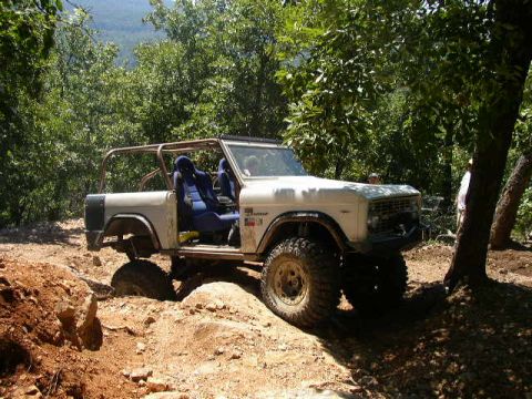 1995 Ford Bronco - This classic Ford Bronco navigates a challenging off-road course surrounded by trees.