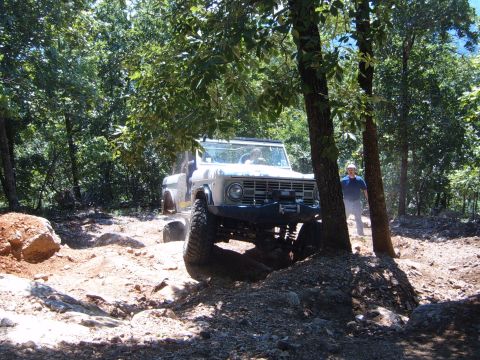 1988 Ford Bronco - White Ford Bronco navigates a challenging off-road course with steep inclines and large rocks.
