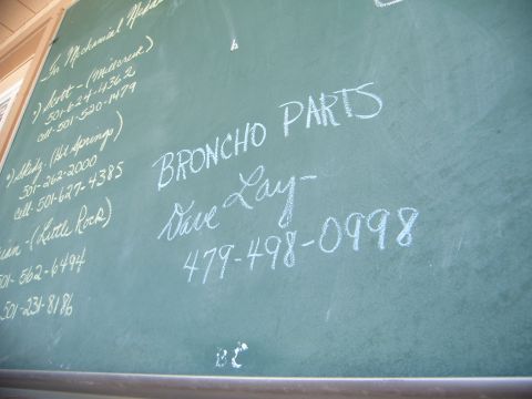 1988 Ford Bronco - A chalkboard displays contact information for 'Broncho Parts' and other listings.