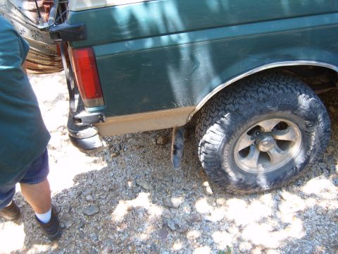 1988 Ford Bronco - Rear view of a green 1988 Ford Bronco, showing the quarter panel and off-road tire.