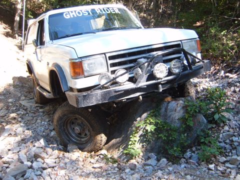 1988 Ford Bronco - White 1988 Ford Bronco tackles a challenging rocky off-road path.