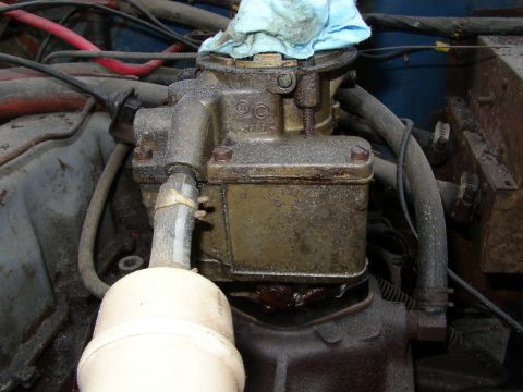 1973 Jeep CJ5 - Engine bay detail shows a carburetor with visible grime and surrounding mechanical components.