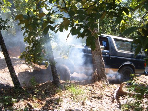 1988 Ford Bronco - A 1988 Ford Bronco kicks up dust and smoke while navigating a wooded trail.