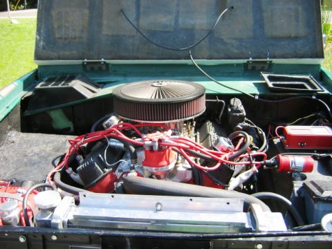 1985 Ford Bronco - The engine bay of a classic SUV is shown with its hood open, revealing the V8 engine and its components.