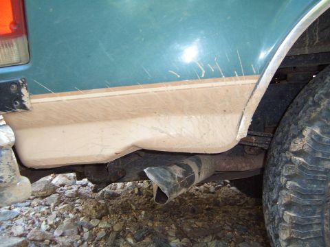 1988 Ford Bronco - Close-up of the rear side of a 1988 Ford Bronco, showing the lower body trim and exhaust.