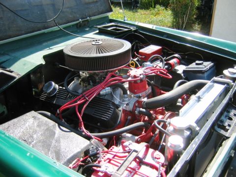 1985 Ford Bronco - The engine bay of a green vehicle is shown with various engine components visible.