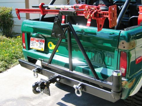 1985 Ford Bronco - This green Ford Bronco features a rear-mounted spare tire carrier and a hi-lift jack secured to the roll cage.