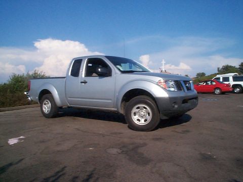 2005 Nissan Frontier - A silver 2005 Nissan Frontier pickup truck is parked outdoors on a sunny day, with other vehicles visible in the background.