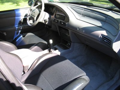 1995 Ford Taurus - The interior of a 1995 Ford Taurus shows a gray dashboard and cloth seats.