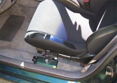 1995 Ford Taurus - Interior view of a car seat base with visible adjustment mechanisms and a green storage box.
