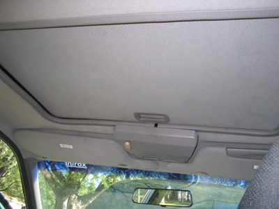 1995 Ford Taurus - The interior of a car is shown, focusing on the sunroof and console area with trees visible outside.