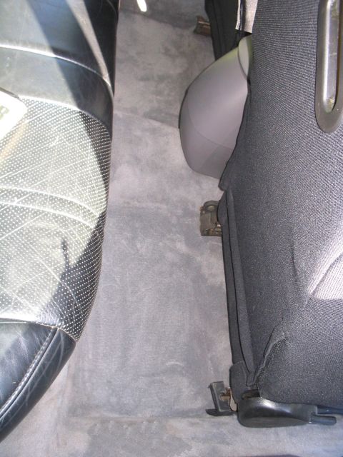 1995 Ford Taurus - Interior view of a car, focusing on the carpet and seats, with a hint of a headrest.