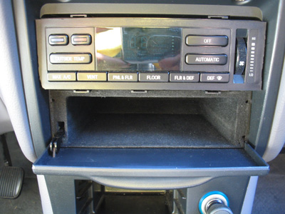 1995 Ford Taurus - Interior view of a car's climate control panel and storage compartment.