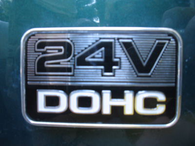 1995 Ford Taurus - A close-up of a "24V DOHC" badge on a green vehicle.