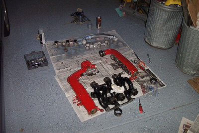 1995 Ford Taurus - Engine intake manifold parts are laid out on newspaper for work in a garage setting.