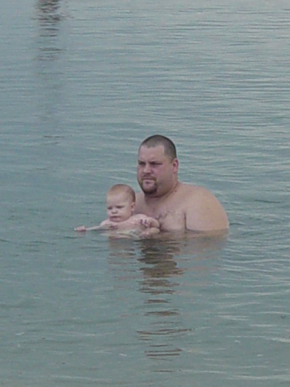 Man holding a baby in the water