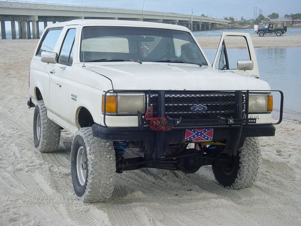 1989 Ford Bronco on beach, front view, white