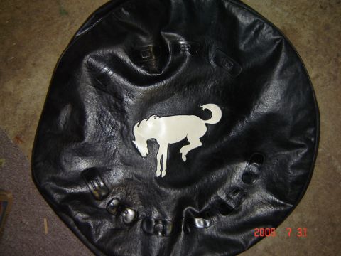 1993 Ford Bronco - Black tire cover the iconic Bronco horse emblem and embossed "FORD" lettering, likely for a 1993 Ford Bronco.