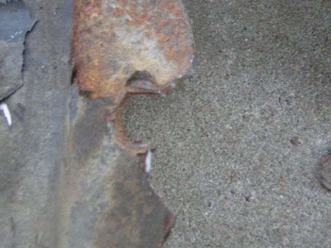 1995 Ford Bronco - A close-up view of a corroded metal component, showing significant rust and damage.
