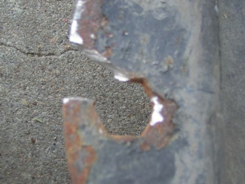 1995 Ford Bronco - A corroded metal component with a distinctive hexagonal opening is shown against a textured ground surface.