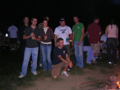 1995 Ford Probe - A group of friends are gathered together outdoors at night, possibly around a campfire.