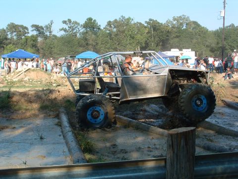 1993 Ford Bronco - A custom-built buggy with a roll cage tackles a challenging obstacle course in the mud.