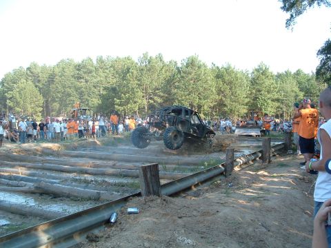 1993 Ford Bronco - An off-road vehicle navigates a challenging obstacle course with a crowd of onlookers.