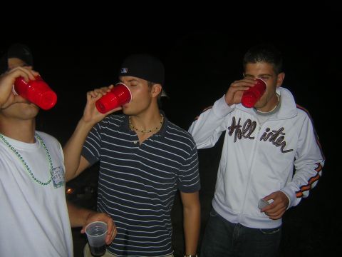 1995 Ford Probe - Three young men are seen drinking from red plastic cups in this nighttime scene.