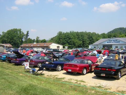 1995 Ford Probe - A gathering of Ford Probes is seen parked in a lot outside a restaurant on a sunny day.