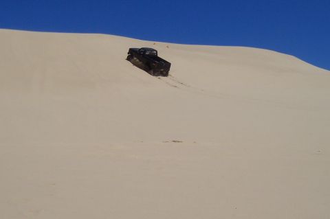 1994 Ford F-150 - Pickup truck navigates a steep sand dune.