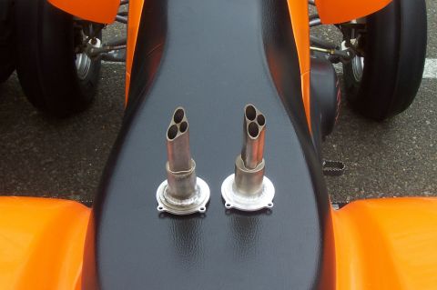 1994 Ford F-150 - Close-up view of the dual quad exhaust pipes mounted on the seat of an orange and black ATV.