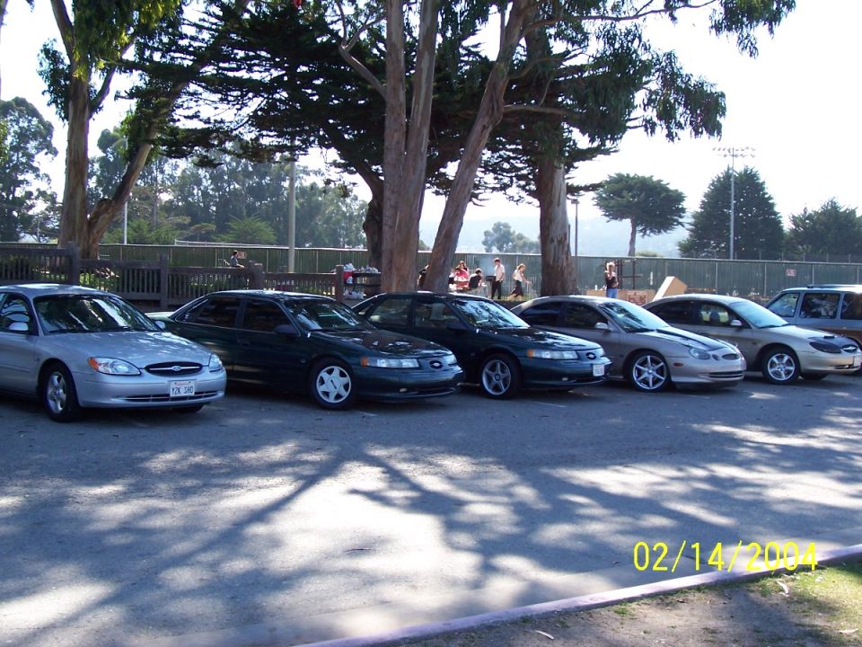 Silver 1996 Ford Taurus sedan parked in a line with other cars