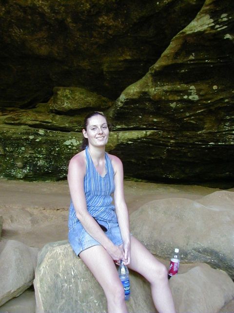 1994 Ford Probe - A woman poses for a photo while sitting on large rocks within a cave, with two water bottles nearby.