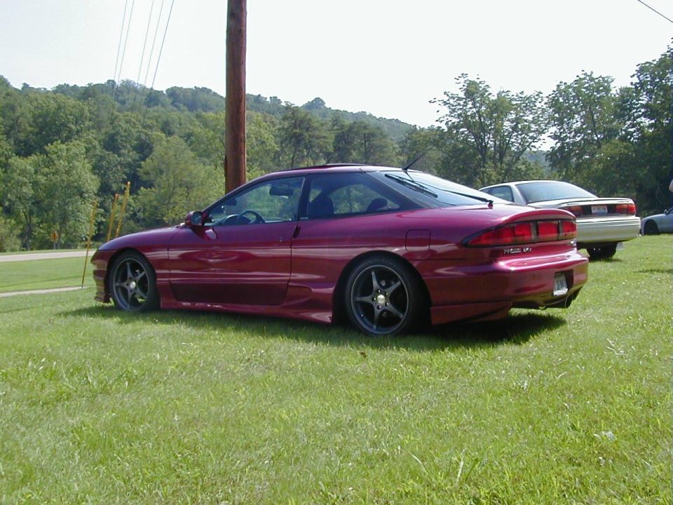 Maroon 1994 Ford Probe parked on grass, another car behind it
