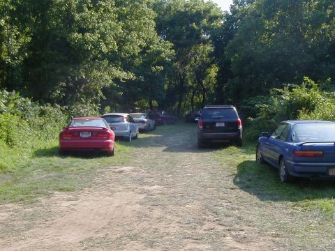 1994 Ford Probe - A red 1994 Ford Probe is parked on the grass in a lot with several other vehicles.